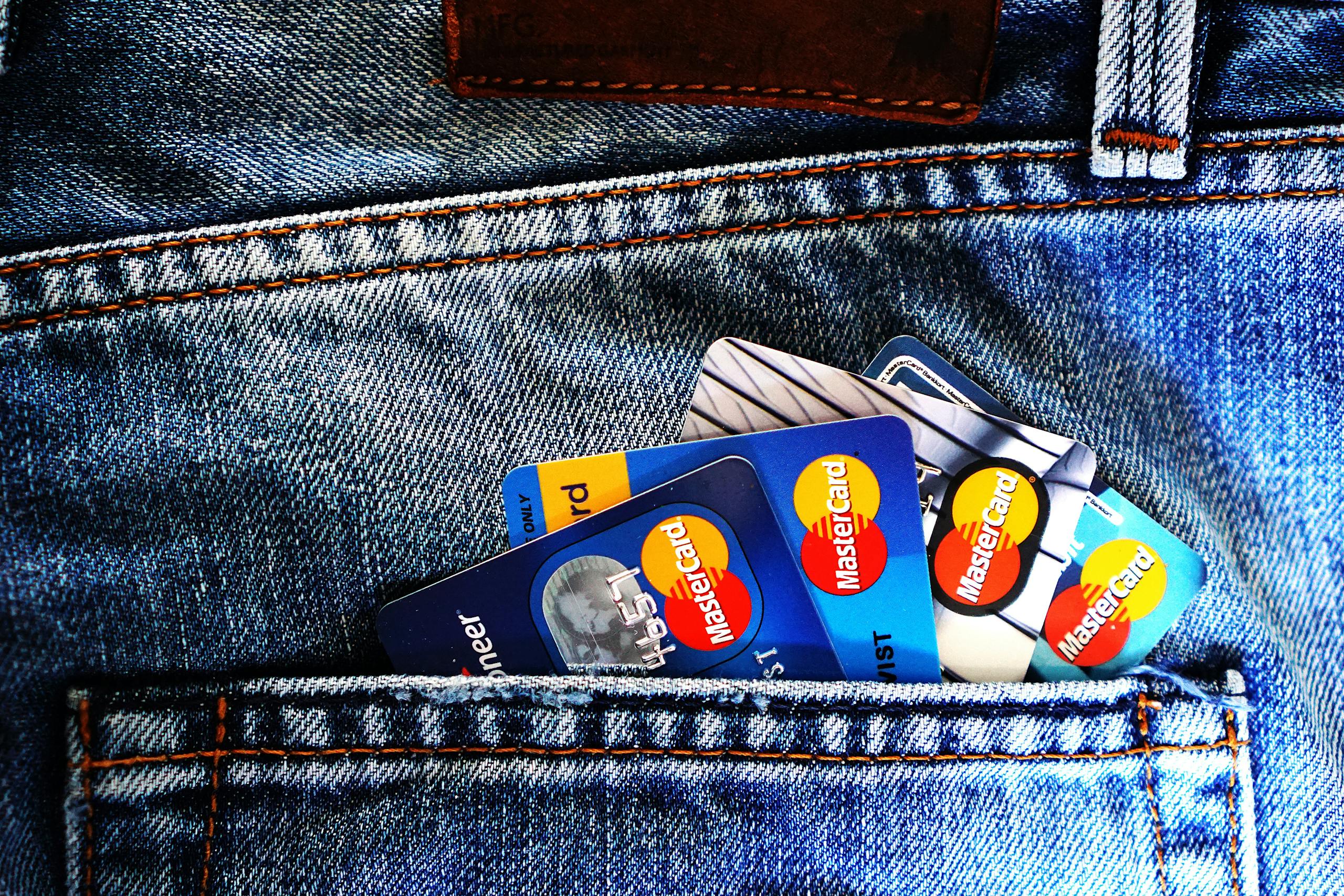 Close-up of a denim pocket with multiple credit cards, illustrating finance and fashion.