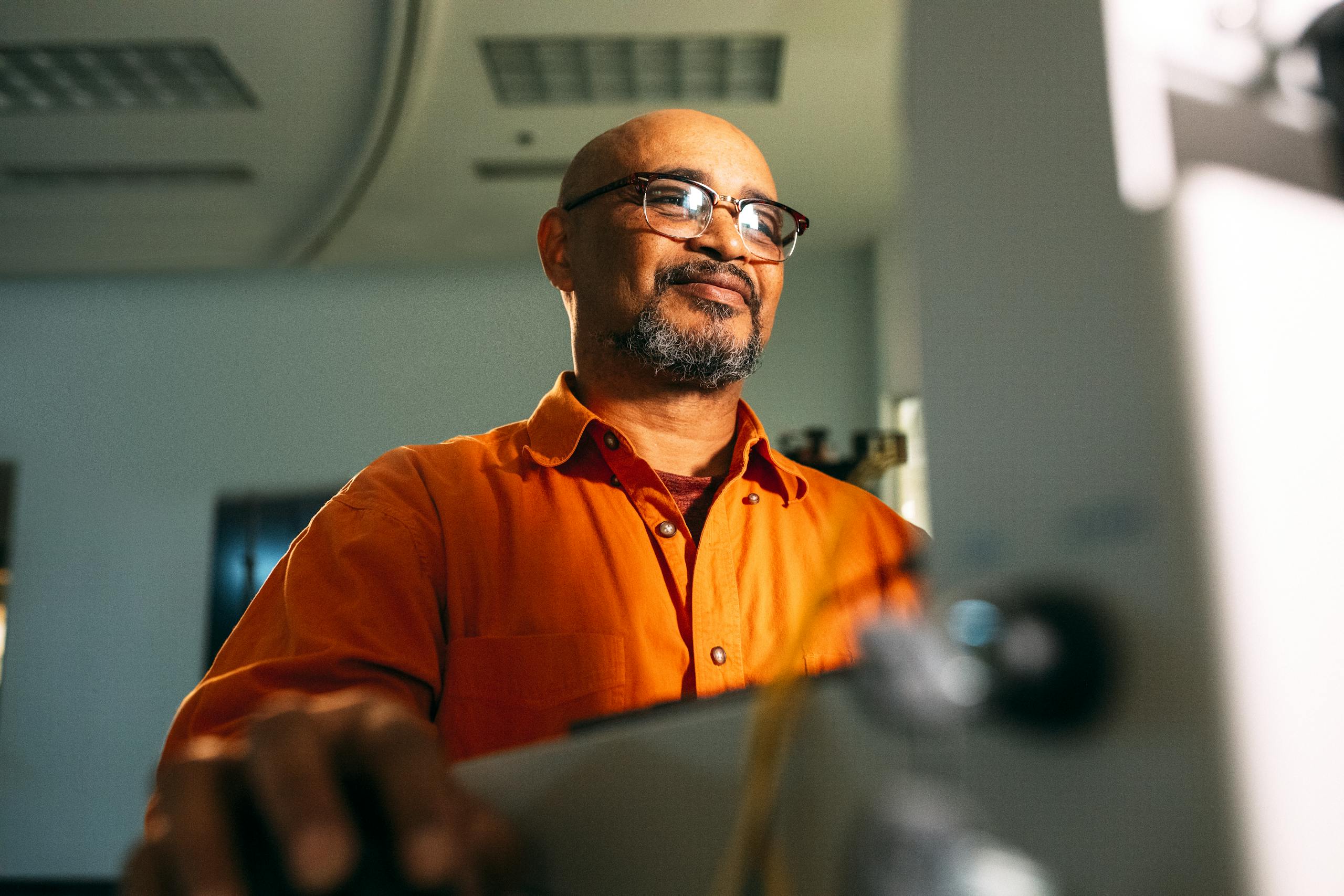 Engineer with eyeglasses intensely working on a computer indoors, focused and professional.